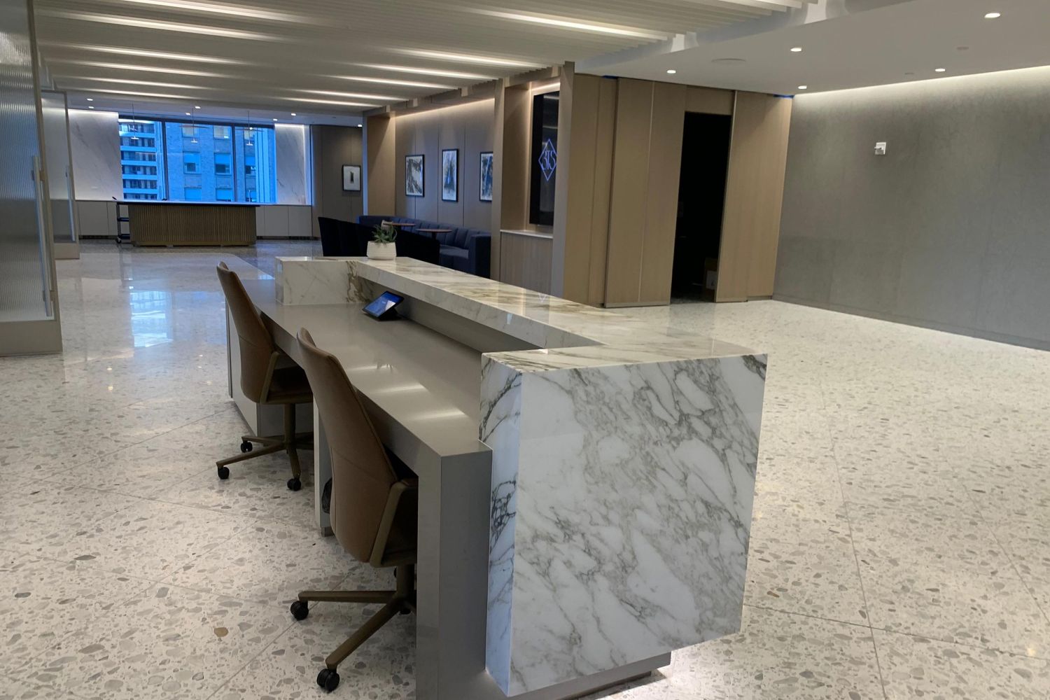 Office lobby with a sleek marble reception desk and open seating area